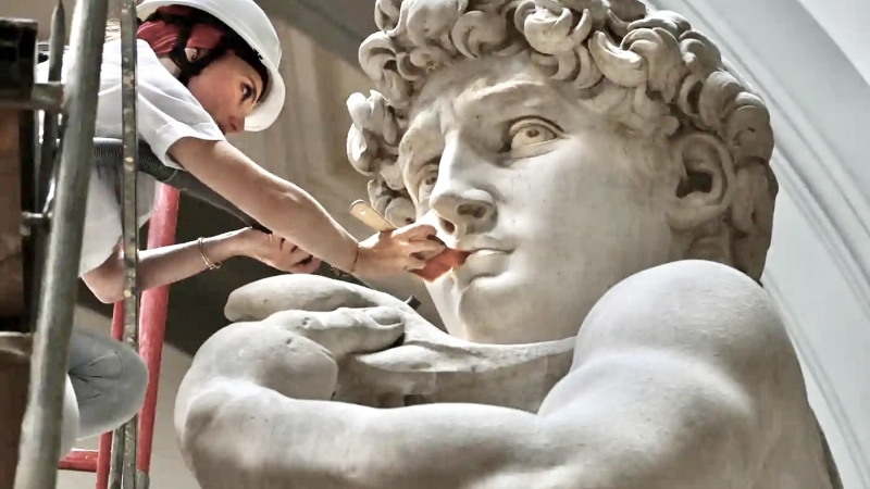 Fotografia dimineții - O restauratoare curață statuia lui David, lucrarea lui Michelangelo, la Galleria dell’Accademia din Florența. Curățarea are loc o dată la fiecare două luni